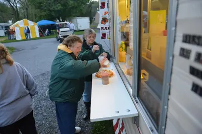 a man and woman buying food from a food truck at Spring Gulch Cottage 1 in Mount Airy