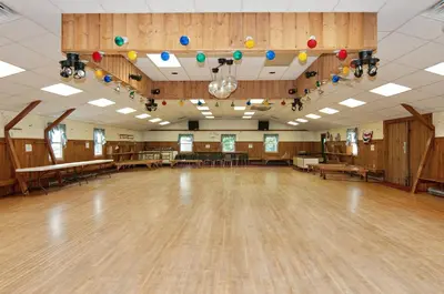 an empty dance hall with wooden floors and colorful balloons at Spring Gulch Screened Park Model 6 in Mount Airy