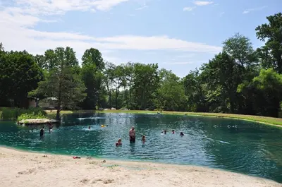 a group of people swimming in a pond at Spring Gulch Screened Park Model 7 in Mount Airy