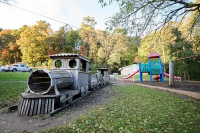 a small train sitting in a park with a playground at Spring Gulch Country House 9 in Mount Airy