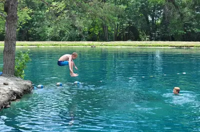 a man jumping into a lake with other people in the water at Spring Gulch Lodge 11 in Mount Airy