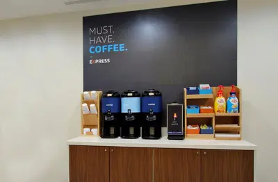 a counter with a bunch of bottles of coffee on it at Holiday Inn Express Tower Center New Brunswick by IHG in East Brunswick