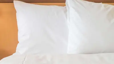a white pillow sitting on top of a bed at Sonesta Simply Suites Parsippany Morris Plains in Morris Plains