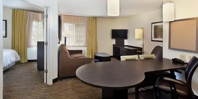 a hotel room with a table and a bedroom at Sonesta Simply Suites Somerset in Somerset
