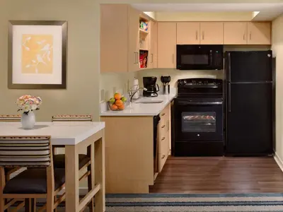 a kitchen with a black refrigerator and a table at Sonesta ES Suites Princeton in Princeton