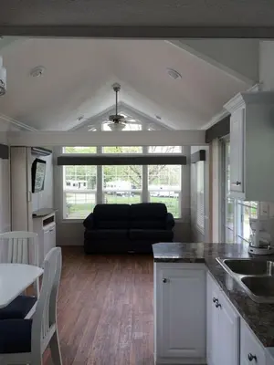 a kitchen and living room with a black couch at Circle M Camping Resort Loft Park Model in Wabank