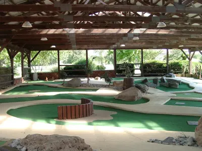 a golf course with rocks and trees in a building at Circle M Camping Resort Screened Park Model in Wabank