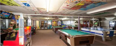 a room with several arcade games and pool tables at Circle M Camping Resort Screened Park Model in Wabank