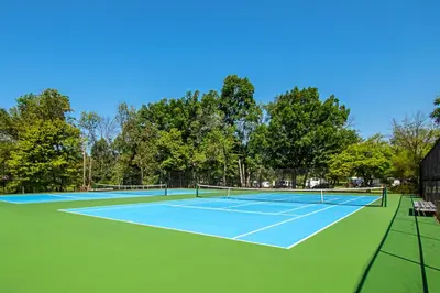 a tennis court with two tennis rackets on it at Hershey Camping Resort Park Model 6 in Mount Wilson