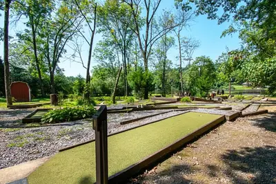 a park with green grass and benches and trees at Hershey Camping Resort Loft Park Model 7 in Mount Wilson