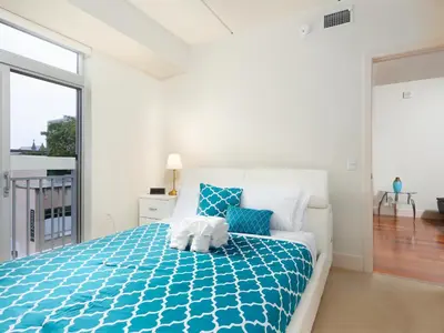 a bedroom with a bed with a blue comforter at Fantastic Philly Fully Furnished Apartments in Philadelphia