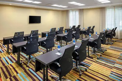 a conference room with tables and chairs and a flat screen tv at Fairfield Inn & Suites by Marriott North Bergen in North Bergen