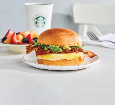 a sandwich on a plate on a table with a bowl of fruit at Courtyard by Marriott Somerset in Somerset