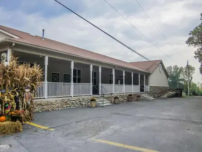 an older building with a white fence and a building at Appalachian Camping Resort Park Model 2 in Shartlesville