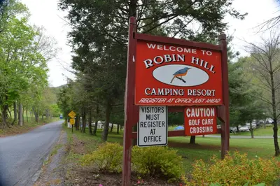 a sign for a rock hill camping resort on a road at Robin Hill Camping Resort One-Bedroom Cottage 8 in Lenhartsville