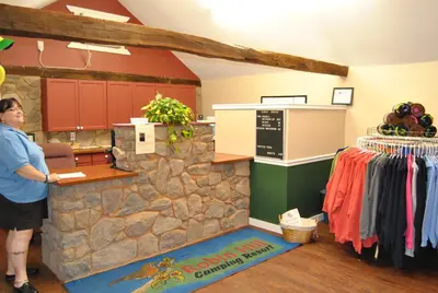 a man standing at the counter of a clothing store at Robin Hill Camping Resort One-Bedroom Cottage 8 in Lenhartsville