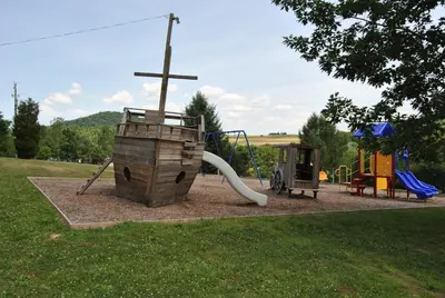 a park with a playground with a cross on it at Robin Hill Camping Resort Deluxe Cottage 13 in Lenhartsville