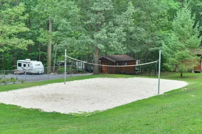 a volleyball court with a net in a yard at Sun Valley Campground Cottage 4 in Maple Grove Park
