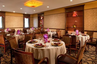 a dining room with tables and chairs with white tablecloths at Chestnut Hill Hotel in Philadelphia