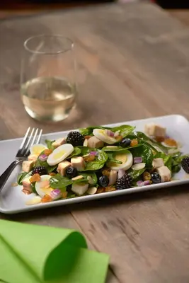 a plate of salad on a table with a glass of wine at Hyatt Place Bethlehem-Downtown in Bethlehem