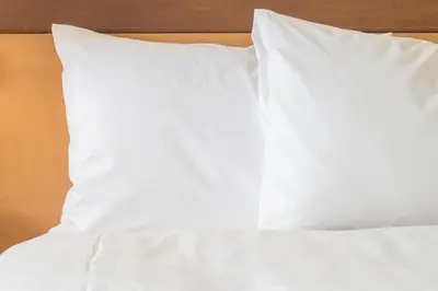 a bed with white sheets and pillows on it at Holiday Inn Express & Suites Jersey City North - Hoboken by IHG in Jersey City