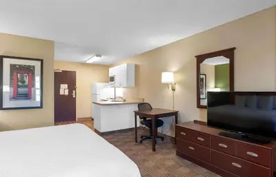 a hotel room with a bed and a desk and a kitchen at Extended Stay America Suites - Elizabeth - Newark Airport in Elizabeth