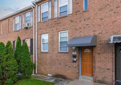 a brick building with a brown door on it at Airport Xpress Guestrooms in Philadelphia