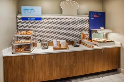 a bakery with a counter with donuts on it at Holiday Inn Express & Suites - North Brunswick by IHG in North Brunswick
