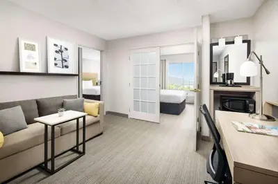 a living room with a couch and a bed at Country Inn & Suites by Radisson, Big Flats (Elmira), NY in Horseheads