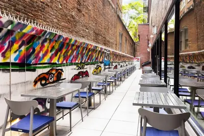 a row of tables and chairs in front of a brick wall at SpringHill Suites by Marriott New York Manhattan/Times Square South in New York