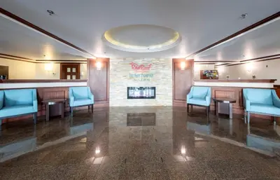 a waiting room with blue chairs and a fireplace at Red Roof Inn & Suites Wilmington – New Castle in New Castle