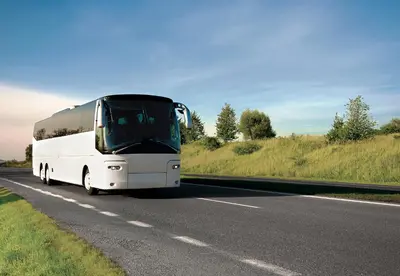 a white bus is driving down a road at Country Inn & Suites by Radisson, York, PA in York