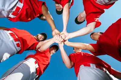 a group of baseball players holding their hands together at Country Inn & Suites by Radisson, Lewisburg, PA in Lewisburg
