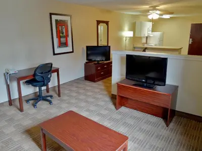 a hotel room with a desk and a television and a chair at Extended Stay America Suites - Allentown - Bethlehem in Bethlehem
