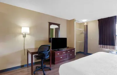 a hotel room with a bed and a desk with a television at Extended Stay America Suites - Newark - Christiana - Wilmington in Rutherford
