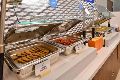 a buffet line with trays of food on a counter at Holiday Inn Express & Suites - Middletown - Goshen by IHG in Middletown