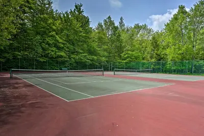 a tennis court with two tennis rackets on it at Deck and Fire Pit Pocono Lake Home Near Skiing! in Pocono Lake