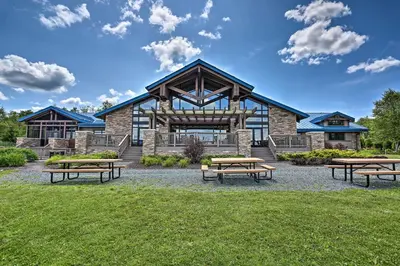 a group of picnic tables in front of a building at Creekside Arrowhead Lake House with Dock and Canoe! in Pocono Lake