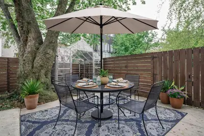 a table and chairs with an umbrella on a patio at Artsy Hidden Gem --- FREE PARKING in Philadelphia