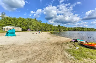 a beach with a tent and two boats on it at Excellent Lakeview Getaway with Watercrafts Included in Pocono Lake