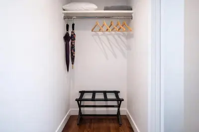 a walk in closet with a black bench and umbrellas at Artsy Hidden Gem - FREE PARKING in Philadelphia
