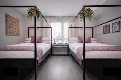 a bedroom with two four poster beds and a window at Artsy Hidden Gem ll -Free Parking --- in Philadelphia