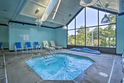 a large swimming pool in a room with windows at Deck, Fire Pit and Pool Access at Poconos Retreat! in East Stroudsburg