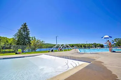 a pool with a water park with a water slide at Walk to Arrowhead Lake Cabin with Private Hot Tub! in Pocono Lake