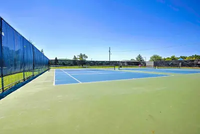 a tennis court with two people playing tennis at Walk to Beach Lakefront Pocono Escape with Fire Pit in Pocono Lake