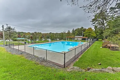 a swimming pool with a fence around it at Fire Pit and Furnished Deck Serene Tobyhanna Escape in Tobyhanna