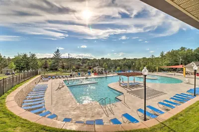 a pool at a resort with blue chairs at Game Room! Tobyhanna Retreat 17 Mi to Ski Slopes in Tobyhanna
