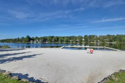 a sandy beach next to a body of water at Game Room! Tobyhanna Retreat 17 Mi to Ski Slopes in Tobyhanna