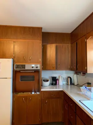 a kitchen with wooden cabinets and a white refrigerator at #3 QueenSize Bed bright room near New Brunswick NJ downtown in New Brunswick