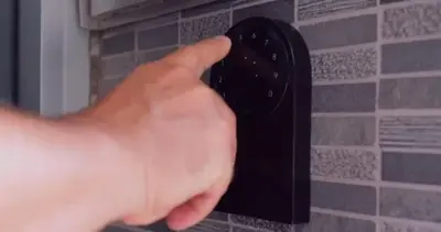 a person holding a black remote control on a wall at 809-2B New bldg Jr columbus circle Balcony WD in New York